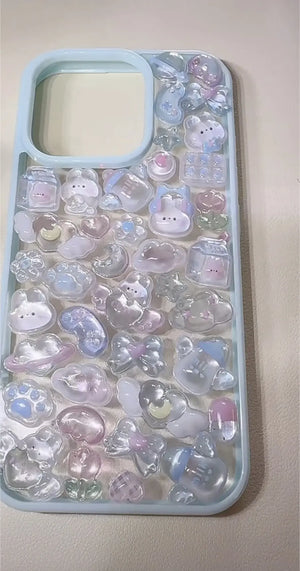 Finished DIY iPhone case with light blue frame, decorated with glossy Bonbon Drop pastel purple-pink jelly stickers, featuring cute rabbits, moons, and celestial designs.