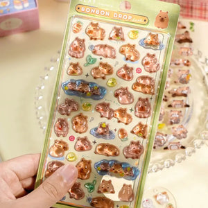 BONBON DROP" cute kawaii sticker sheet with glossy capybara designs, perfect for DIY phone case decoration.