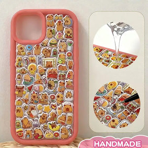 Finished DIY iPhone case with coral orange frame, decorated with dense capybara and food stickers, creating a warm cozy capybara paradise aesthetic.