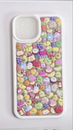 Finished DIY iPhone case with white frame, decorated with dense mini fruit and cute character stickers in pastel colors, creating a fresh fruity aesthetic.