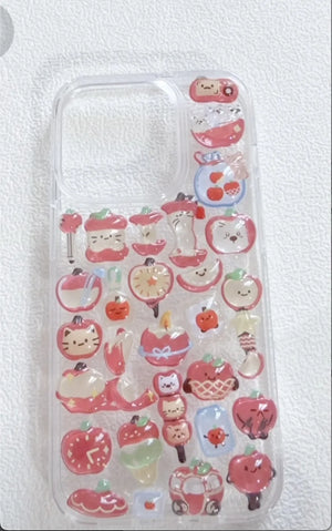 Finished DIY clear iPhone case decorated with glossy red apple and cute cat stickers, featuring a warm sweet aesthetic.