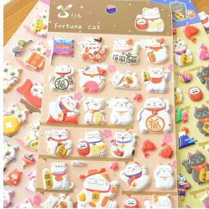 Display of multi-color "Fortune Cat" 3D puffy stickers, showing various cute lucky cat designs in different color schemes.
