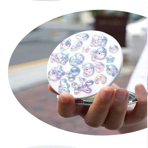 Decorative display of 3D iridescent crystal stickers used for compact mirror DIY, featuring cute pet and star designs with holographic effects