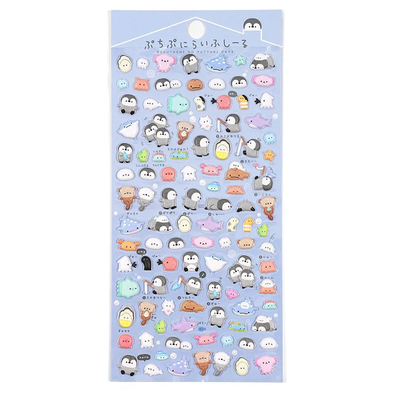 A blue retail sheet of Japanese kawaii aquarium 3D puffy drop-seal stickers featuring cute little penguins, seals, otters, stingrays, and jellyfish for DIY phone crafting.