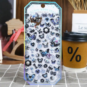 A retail package of premium Ecrin Reve Seal 3D puffy stickers with shimmering holographic aurora gradients, butterfly shapes, and dark crystal details for DIY phone case crafting.
