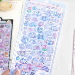 Handheld display of "BONBON DROP" 3D crystal puffy sticker sheet with ocean pet designs, showcasing cute sea creatures and iridescent effects