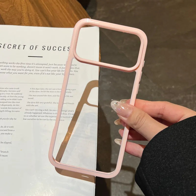 A minimalist hybrid protective phone case with a soft pastel pink border frame and a crystal clear transparent back panel, held in hand.