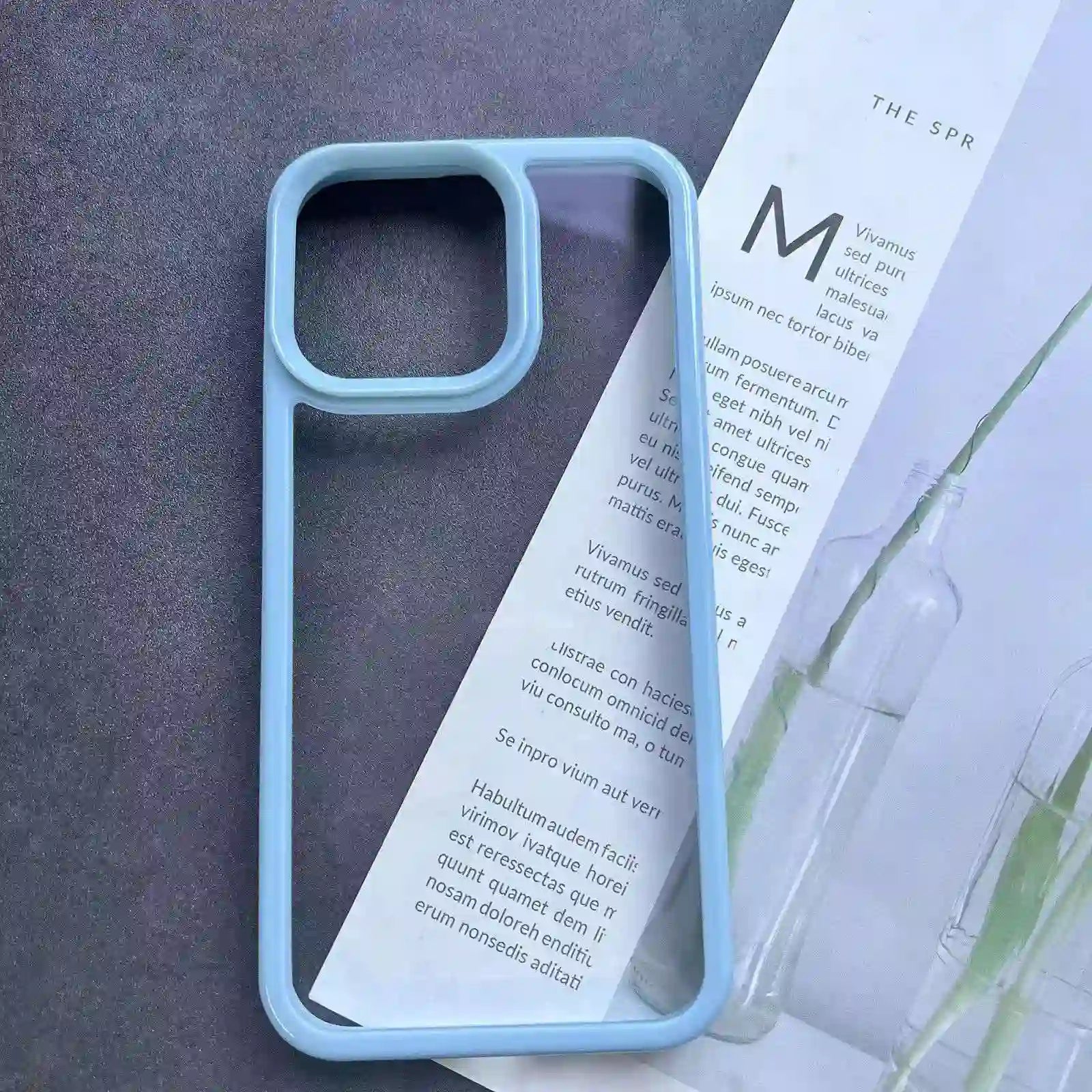Clear DIY phone case for iPhone with light blue protective frame and transparent back panel, featuring raised camera protection, ready for sticker decoration.