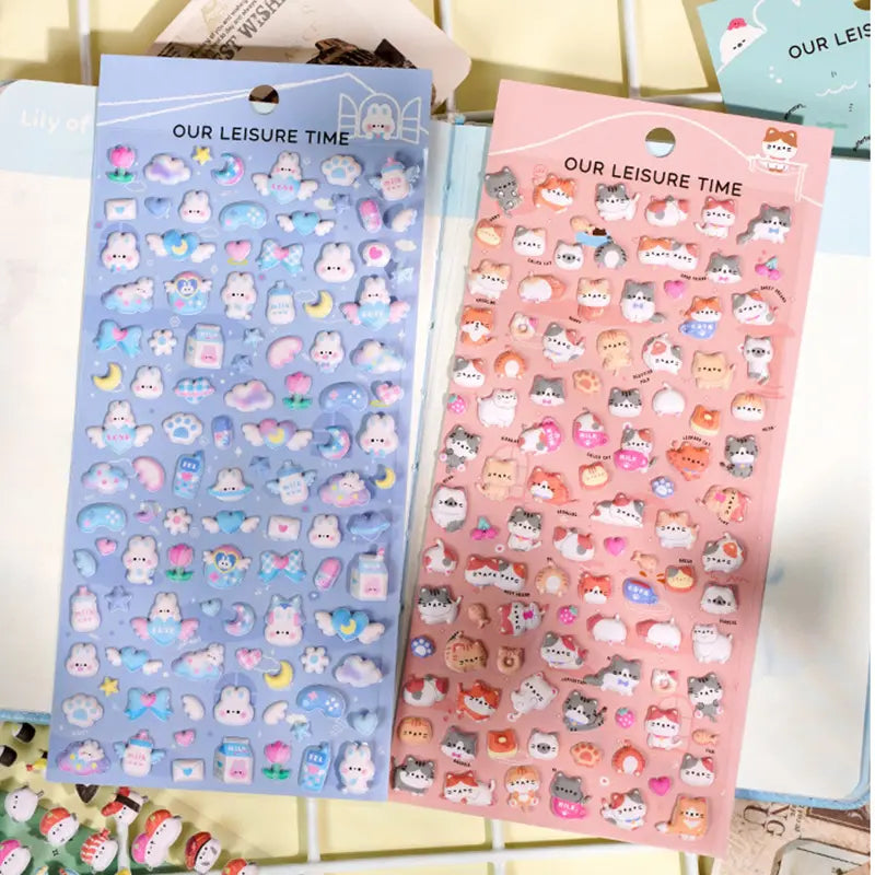 Handheld display of 4 styles of 3D embossed bubble stickers (sushi, dessert, blue rabbit, cat), cute pastel patterns, PVC self-adhesive