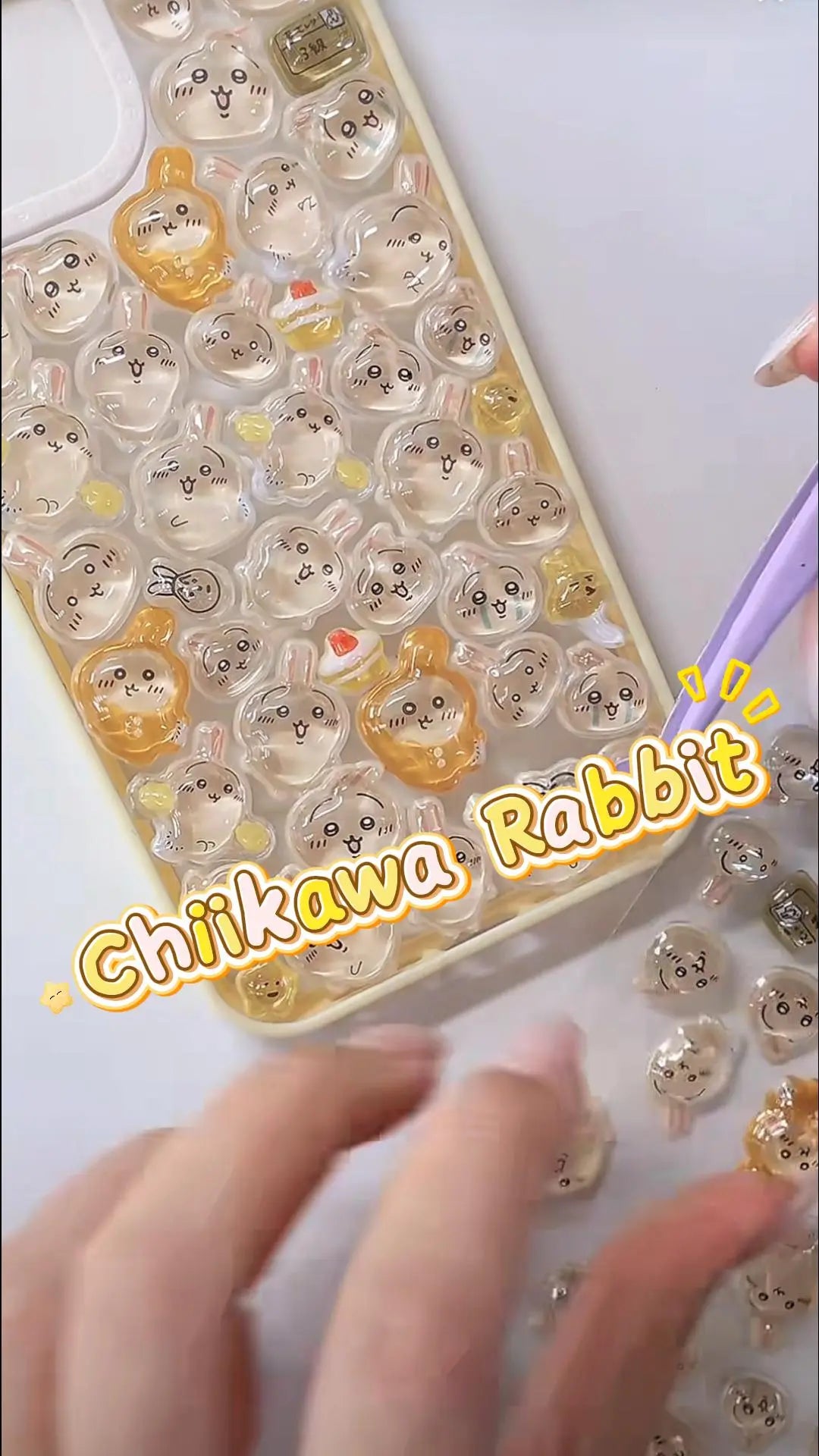 Handcrafted phone case with a creamy yellow border, densely filled with a 3D collage of glossy, transparent Chiikawa Usagi rabbit character charms and mini pudding treats.
