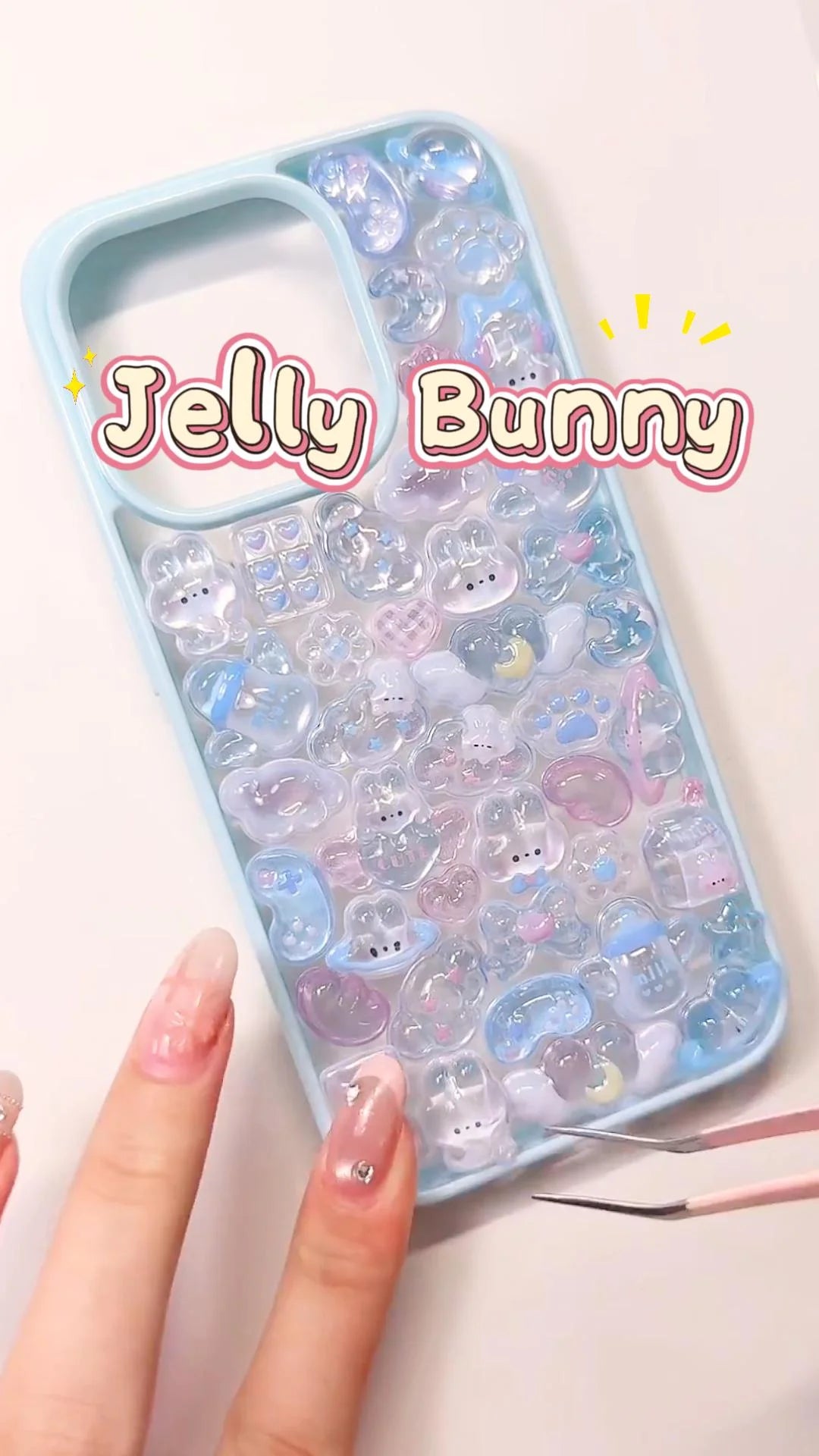 Handcrafted clear phone case with a light blue wide border, densely filled with a 3D collage of glossy, holographic aurora rabbit charms, milk boxes, and cat paw details.