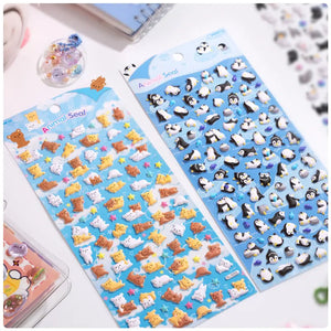 Handheld display of 2 sheets: penguin & corgi/cat 3D bubble stickers, blue background, PVC self-adhesive	