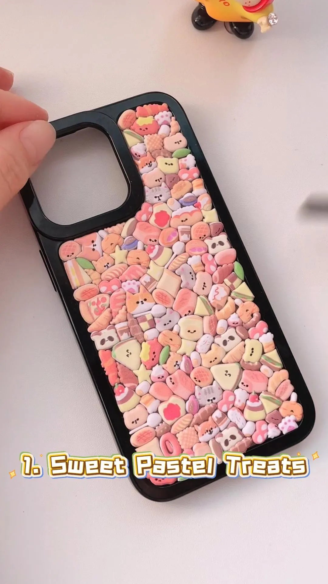 Handcrafted clear phone case with a sleek black border, densely filled with a 3D collage of glossy, pastel-toned cartoon sandwiches, toast loaves, croissants, and cat pastries.