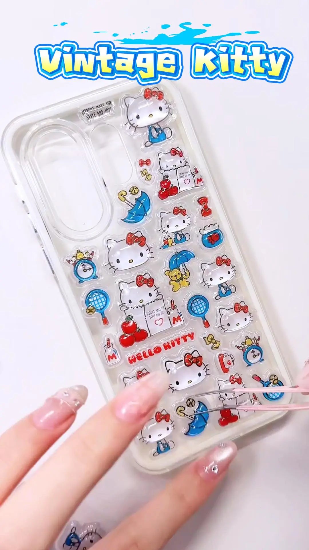 Handcrafted phone case with a soft cream white border, densely filled with a 3D collage of glossy, transparent retro Hello Kitty charms, red apples, and blue tennis rackets.