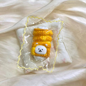 Golden egg-roll-shaped squishy with a white bear face in clear packaging.