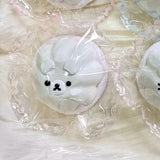 White pudding-shaped squishy with a bear face in clear packaging.