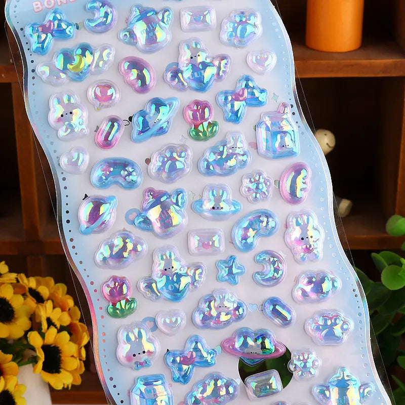 Close-up of 3D crystal clear blue "BONBON DROP" stickers with adorable iridescent pet and paw designs, featuring holographic and glitter effects, self-adhesive PVC epoxy stickers