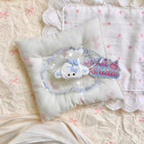 White cat-shaped squishy wearing a pale blue long-eared hood in clear packaging.