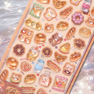 Close-up of 3D crystal clear bread pet stickers with adorable bear, croissant, and donut designs, featuring iridescent and glitter effects, self-adhesive PVC epoxy stickers