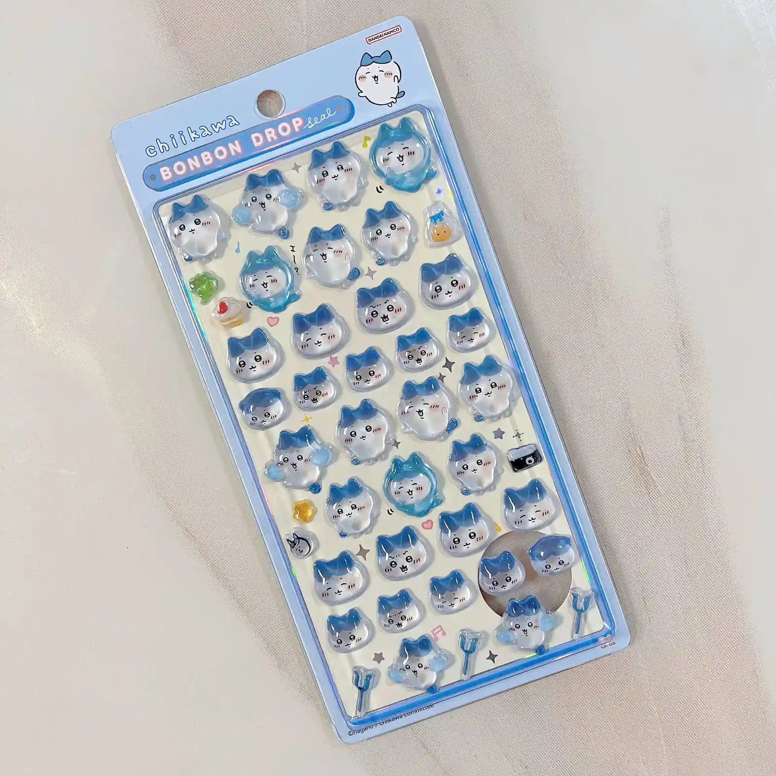 An official style sheet of Chiikawa Bonbon Drop Seal 3D puffy stickers featuring various cute expressions of Hachiware cat.