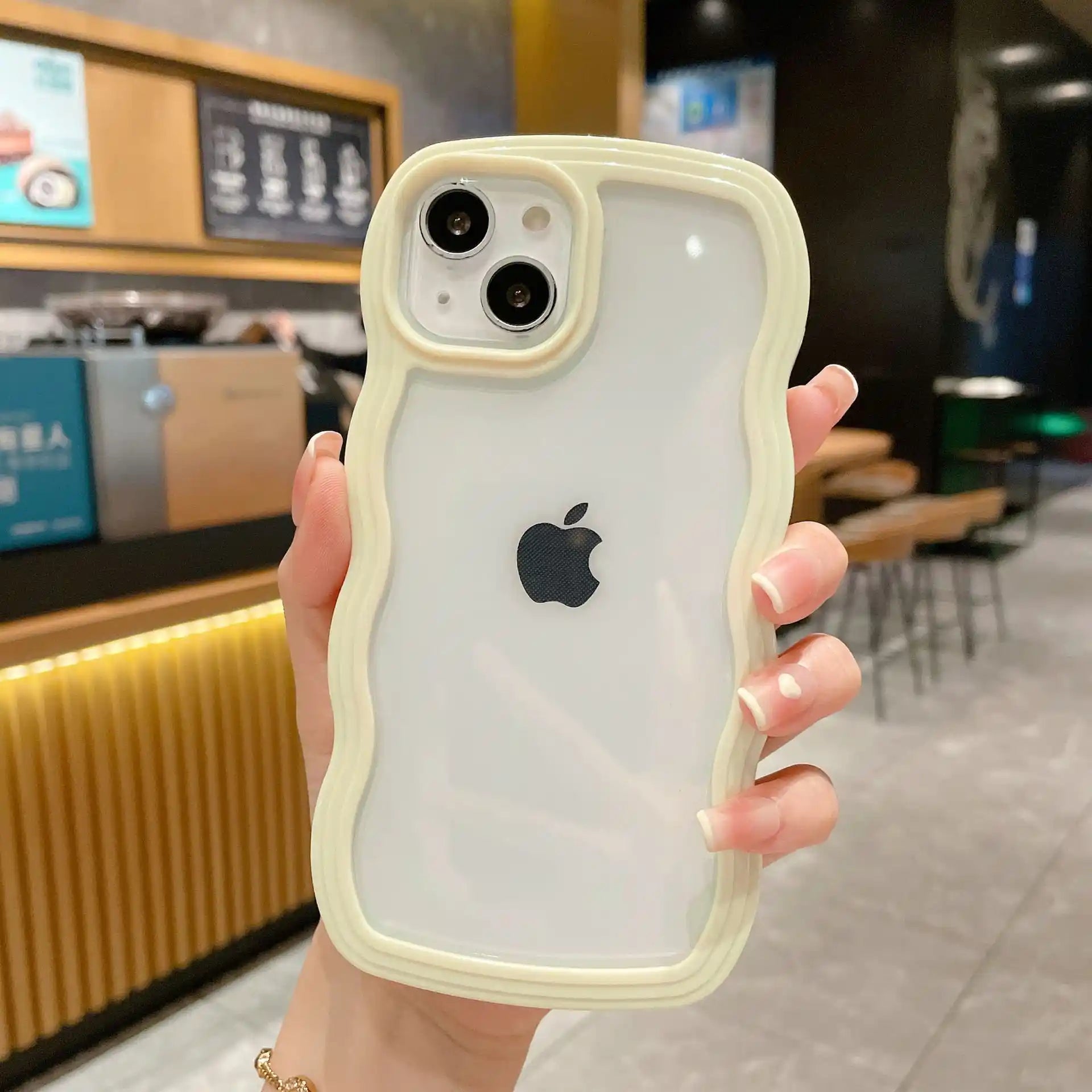 Clear DIY phone case for iPhone with cream-colored wavy protective frame and transparent back panel, featuring raised camera protection, ready for sticker decoration.