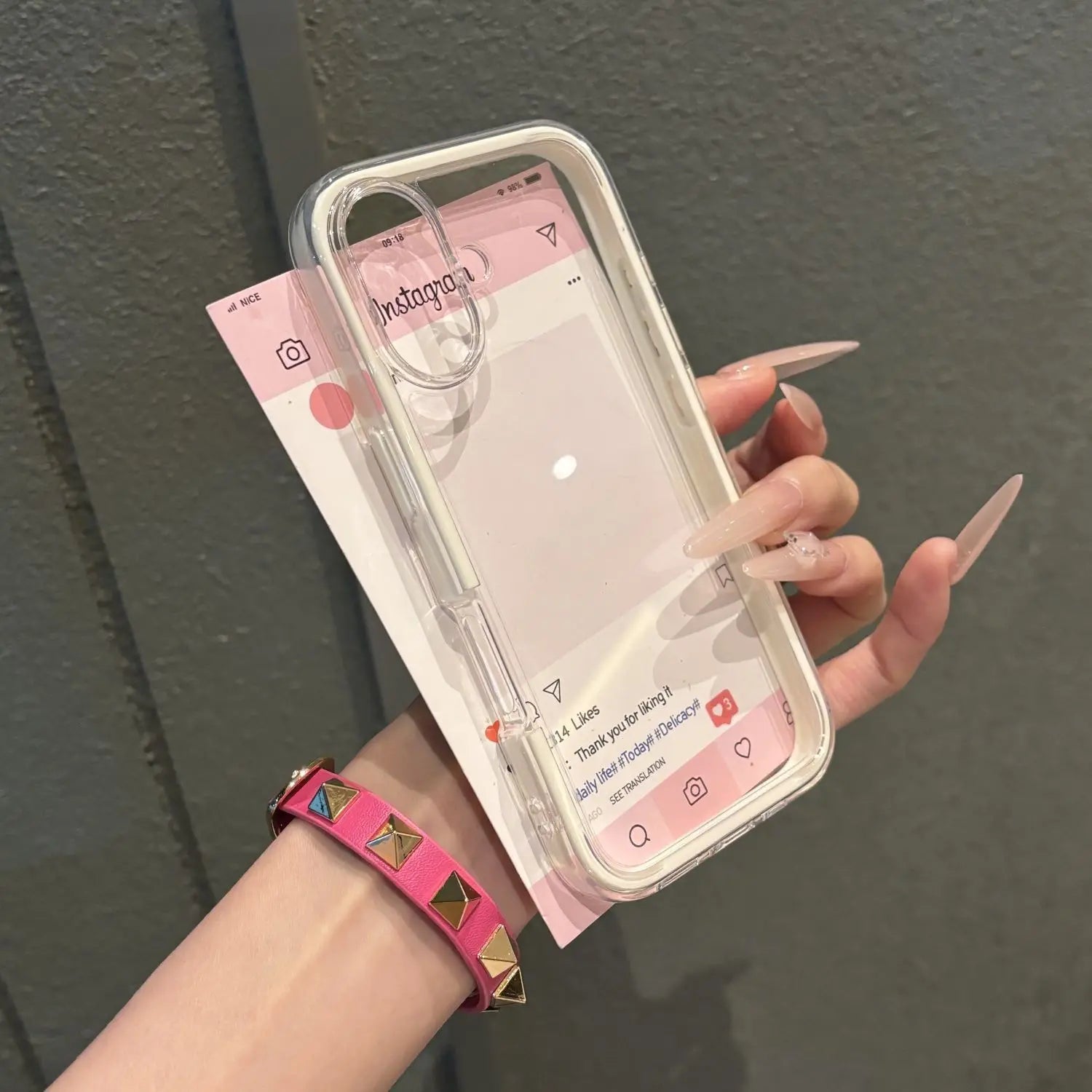 A premium cream white three-in-one protective acrylic phone case with a clear elevated camera bezel, held in hand against a neutral background.