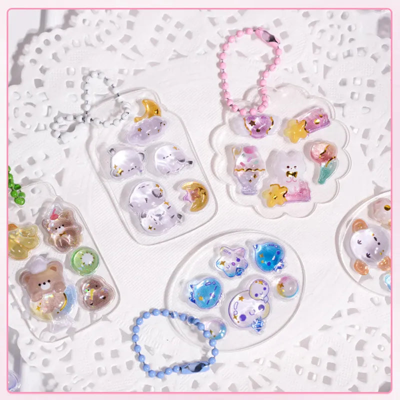 Decorative display of 3D crystal clear stickers with cute animal and celestial designs, used for keychain and DIY crafts
