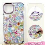 Finished display of handmade DIY phone case decorated with 3D crystal pet stickers, featuring cute animal and candy designs with iridescent effects