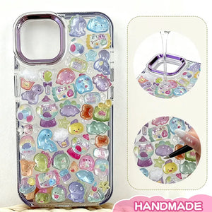 Finished display of handmade DIY phone case decorated with 3D crystal pet stickers, featuring cute animal and candy designs with iridescent effects