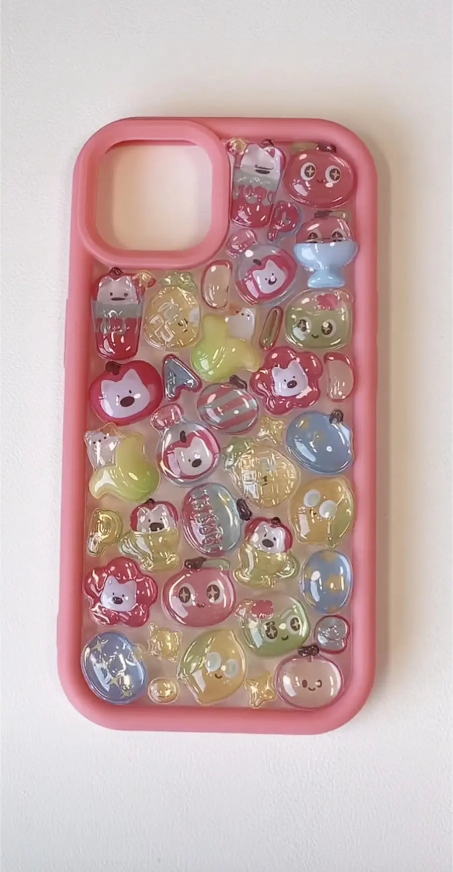 Finished DIY iPhone case with pink frame, decorated with glossy 3D Fruity Diary kawaii stickers, including cute fruit and character designs in pastel colors.
