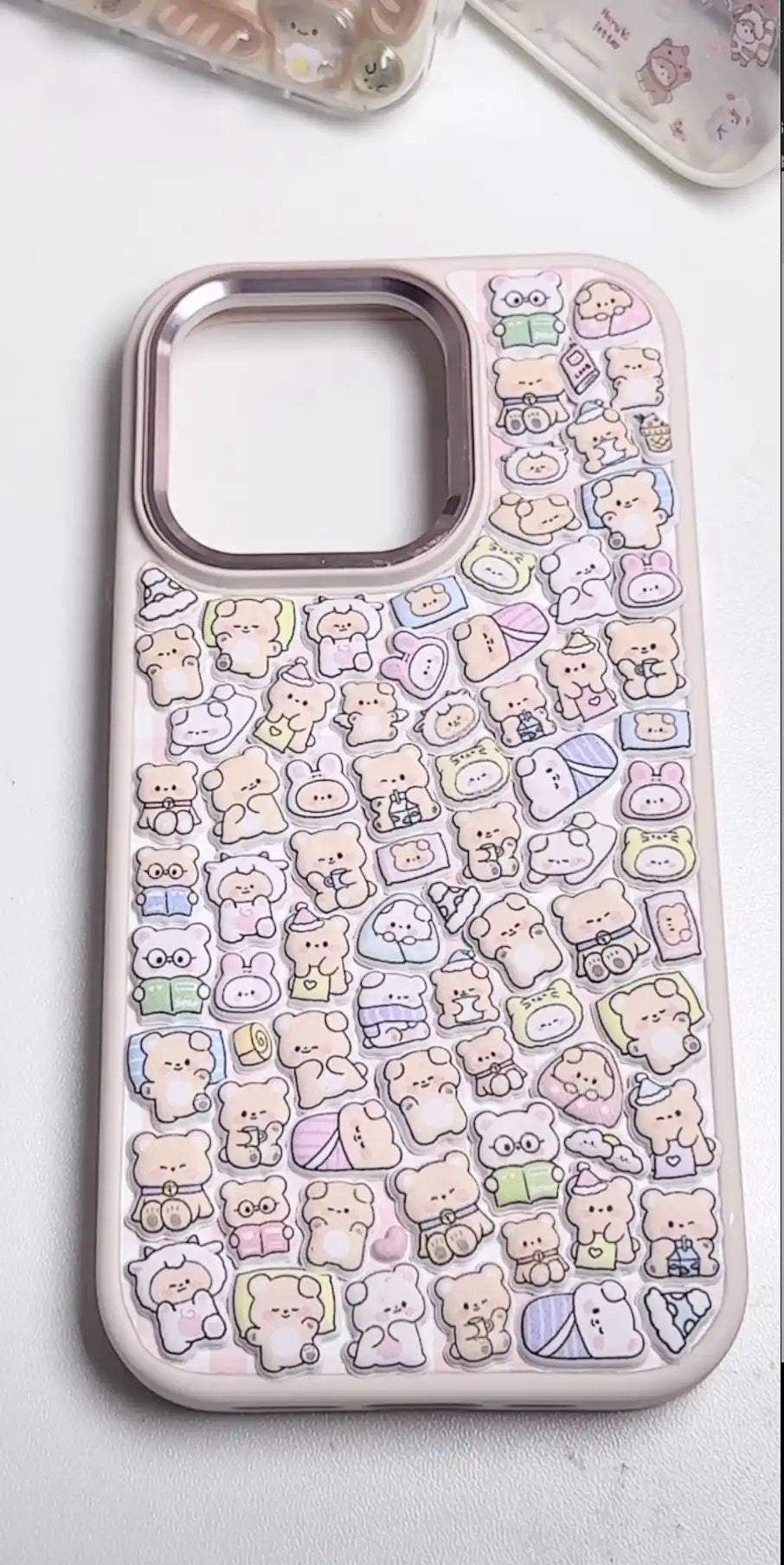 Finished DIY iPhone case with pink frame, decorated with dense mini bear and cute animal stickers, creating a cozy pastel kawaii aesthetic.