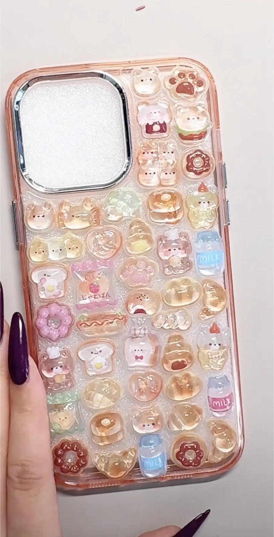Finished DIY iPhone case with rose gold frame, decorated with glossy Bonbon Drop bread and dessert stickers, including cute bears, donuts, and milk bottle designs.