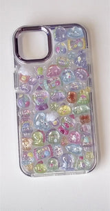 Finished DIY iPhone case with purple frame, decorated with glossy Bonbon Drop candy and dinosaur stickers, featuring pastel colors and cute jelly-style designs.