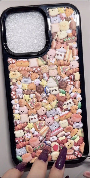 Finished DIY iPhone case with black frame, decorated with dense mini bread, pastry, and cute animal stickers, creating a cozy bakery aesthetic.