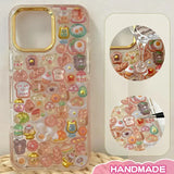 Finished DIY iPhone case with shiny gold edge frame, decorated with dense glossy bread and bear stickers, creating a warm and luxurious bakery aesthetic.