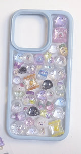 Finished DIY iPhone case with light blue frame, decorated with glossy pastel ghost and snack jelly stickers, creating a dreamy whimsical aesthetic.