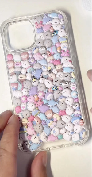 Finished DIY clear iPhone case decorated with a dense array of cute pastel sea creature stickers, including seals, penguins, and other kawaii marine animals.