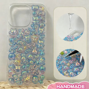Finished DIY clear iPhone case, decorated with dense holographic bear and rabbit stickers, creating a shiny iridescent aesthetic.