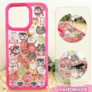 Finished DIY iPhone case with hot pink frame, decorated with dense glossy lucky cat and daruma stickers, creating a festive and lucky aesthetic.