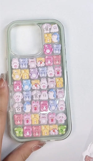 Finished DIY iPhone case with mint green frame, decorated with dense glossy Jelly Family jelly animal stickers, featuring a pastel colorful kawaii aesthetic.