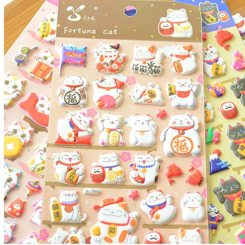 Display of multi-color "Fortune Cat" 3D puffy stickers, showing various cute lucky cat designs in different color schemes.