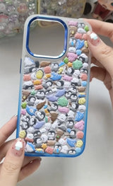 Final product of a handmade DIY phone case featuring 3D resin penguins and summer dessert charms on a white wave-edge frame.