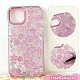 Finished display of handmade DIY phone case with full cherry blossom print, pink frame, and iridescent pink flower patterns