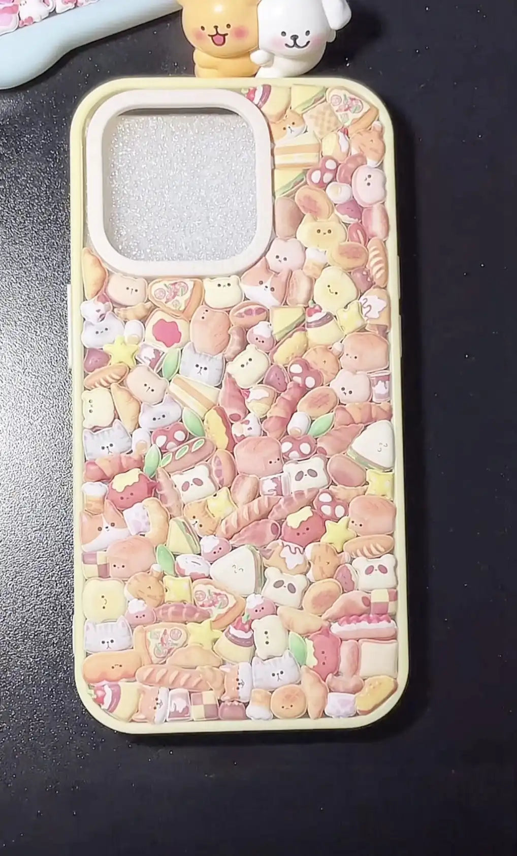 Final product of a handmade DIY phone case densely covered in 3D resin bread and bakery-themed charms.
