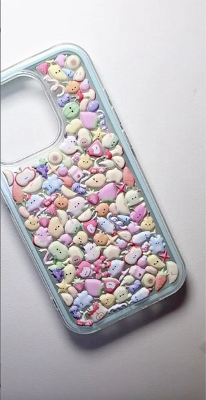 Final product of a handmade DIY phone case densely covered in 3D resin fruit and dessert charms, kawaii aesthetic.