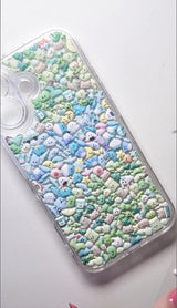 Final product of a handmade DIY phone case covered entirely in tiny pastel-colored 3D resin charms for a mosaic aesthetic.