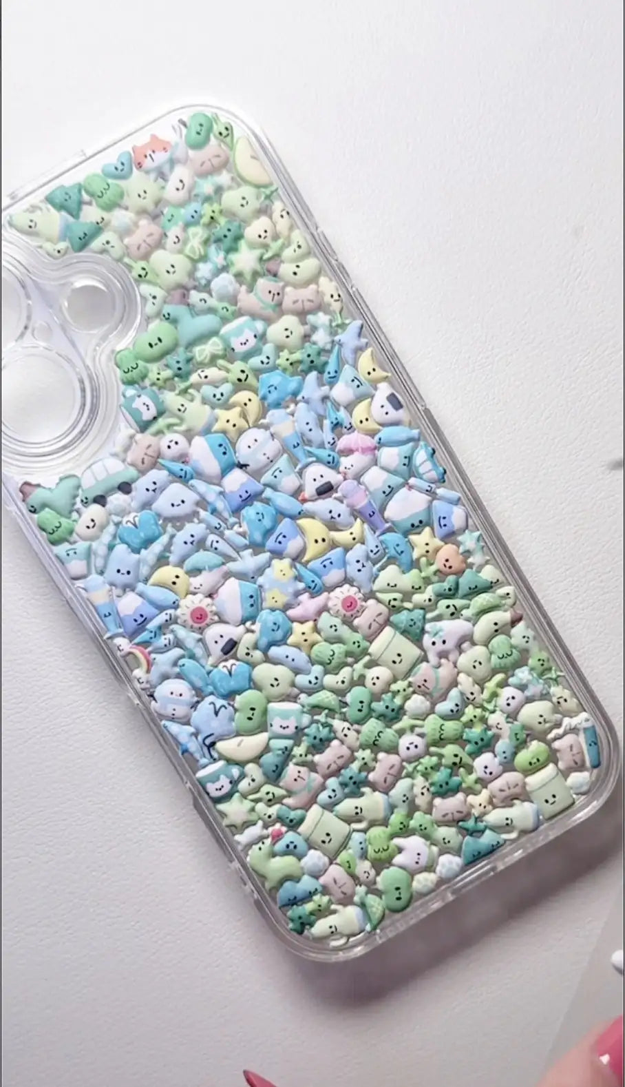 Final product of a handmade DIY phone case covered entirely in tiny pastel-colored 3D resin charms for a mosaic aesthetic.
