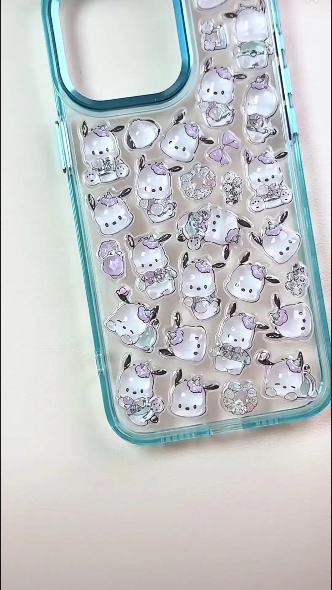 Handcrafted icy clear blue 3D phone case with a dense collage of cute squishy Pochacco dogs, colorful tulips, and peach charms.
