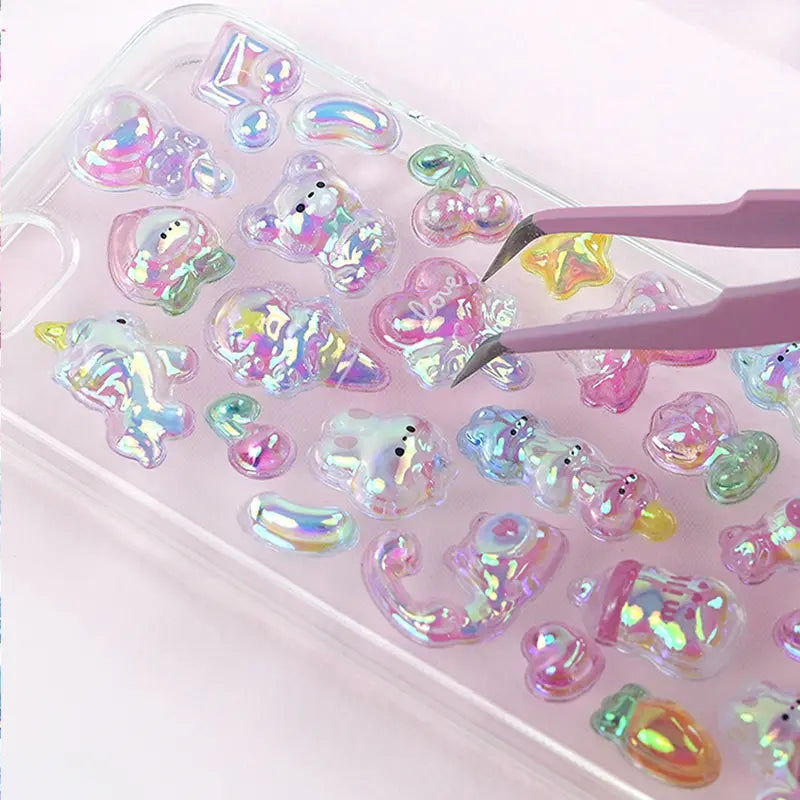 Decorative display of 3D iridescent crystal stickers used for phone case DIY, featuring cute pet and heart designs with holographic effects, ideal for customizing electronic devices
