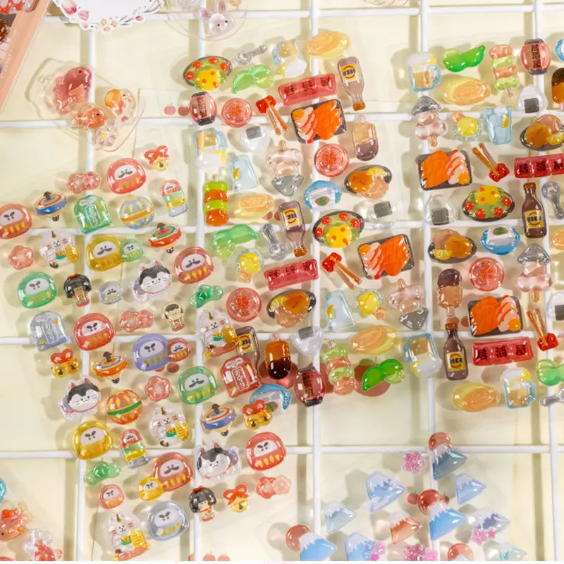 Decorative display of 3D Japanese daruma and sushi crystal stickers used for grid wall DIY, featuring cute traditional Japanese designs with iridescent effects
